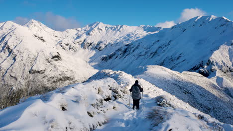 foto trasera de un montañero haciendo senderismo en la cima de montañas nevadas en la pista kepler en nueva zelanda