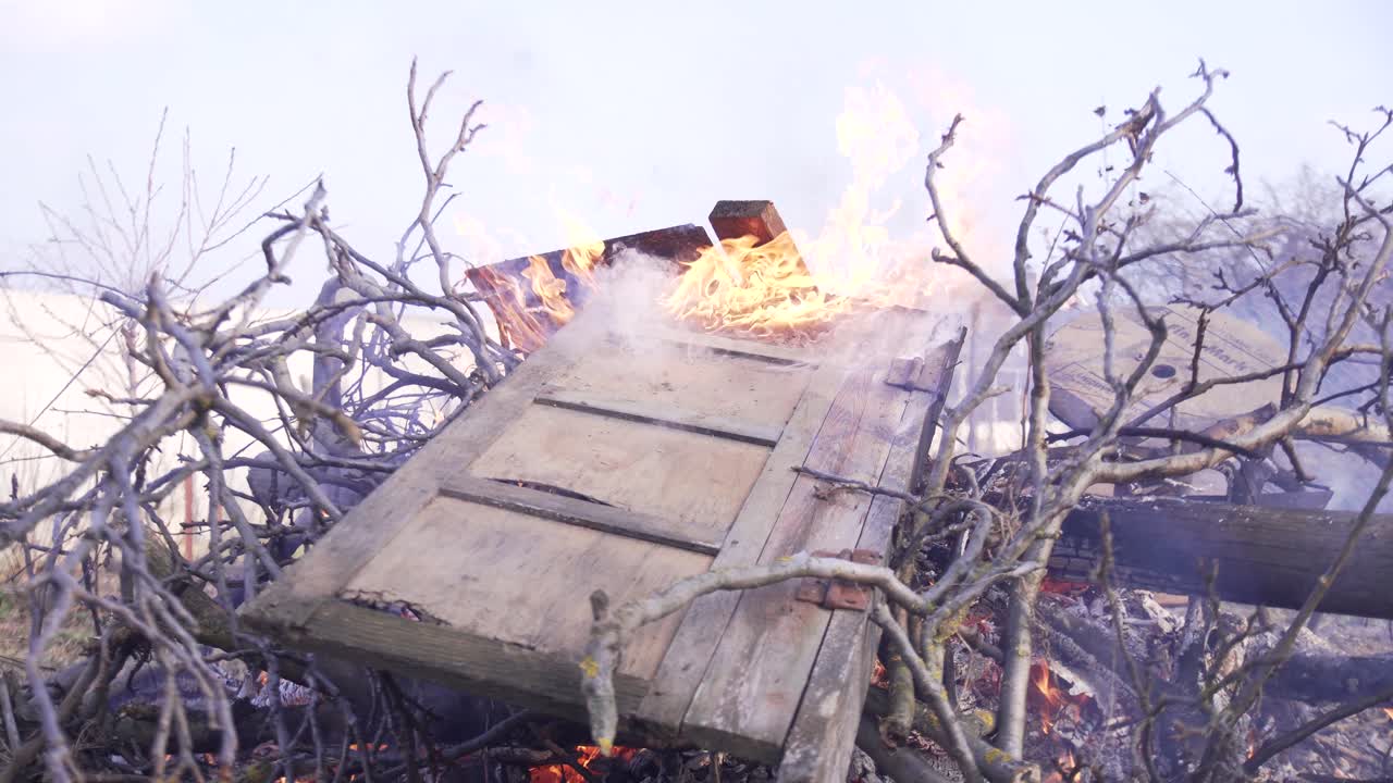 A pile of branches and wooden debris burning