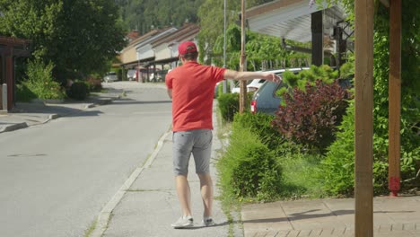 slow motion rude courier making his round around the suburbs kicks three parcels