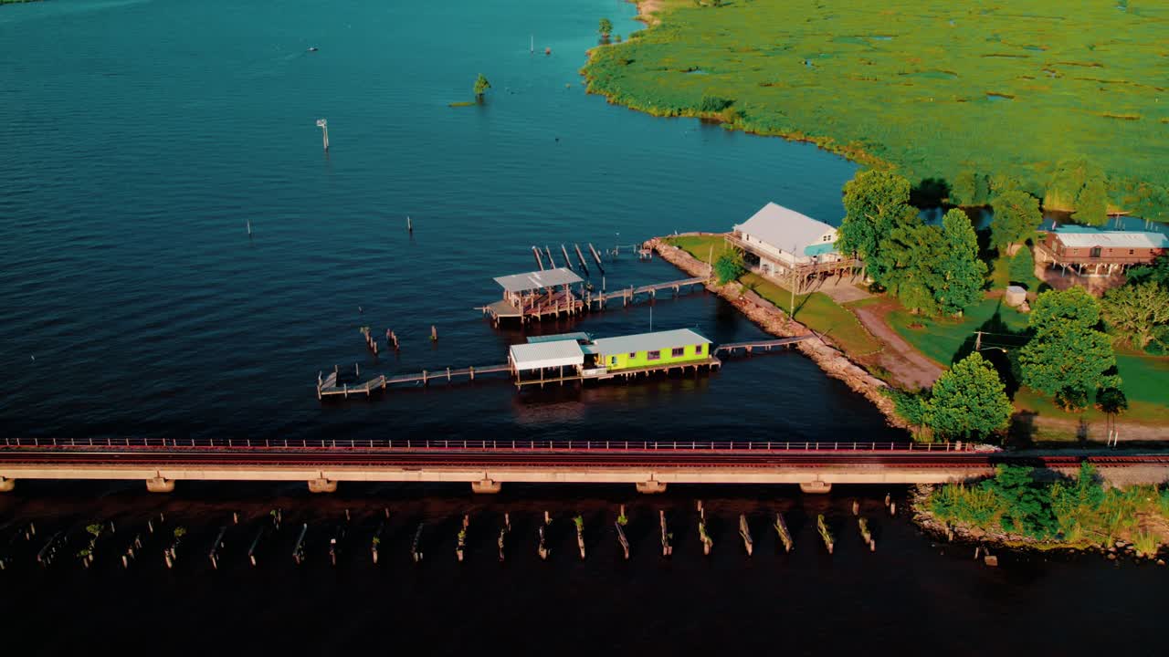 Akers, LA showing stilt cabins, boat docks, and marshy shoreline. Southern lifestyle footage. Elevated boathouse for Floating fishing camp.