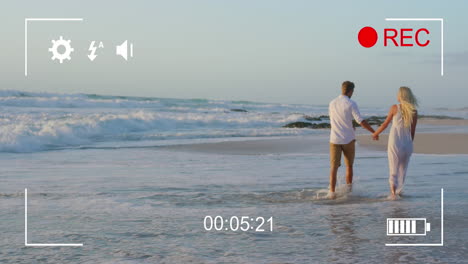filmando una pareja en una playa con una cámara digital 4k