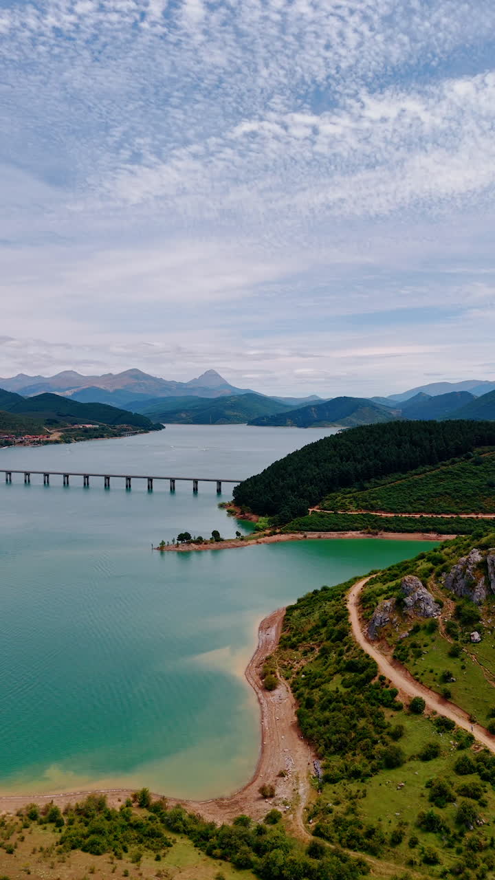 Spectacular view of nature in national park of Leon, Spain, Europe. Approaching the lake in the mountains with a bridge above it. Aerial view. Vertical video.