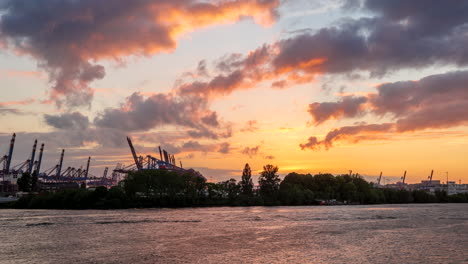 Toma-De-Timelapse-Al-Atardecer-De-La-Silueta-Del-Puerto-De-Hamburgo,-Cielo-Dorado