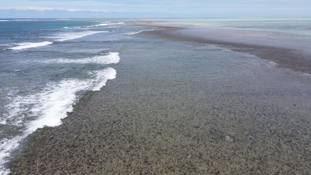 una vista aérea muestra las olas azules chocando contra los vibrantes arrecifes de coral que rodean viti levu, fiji