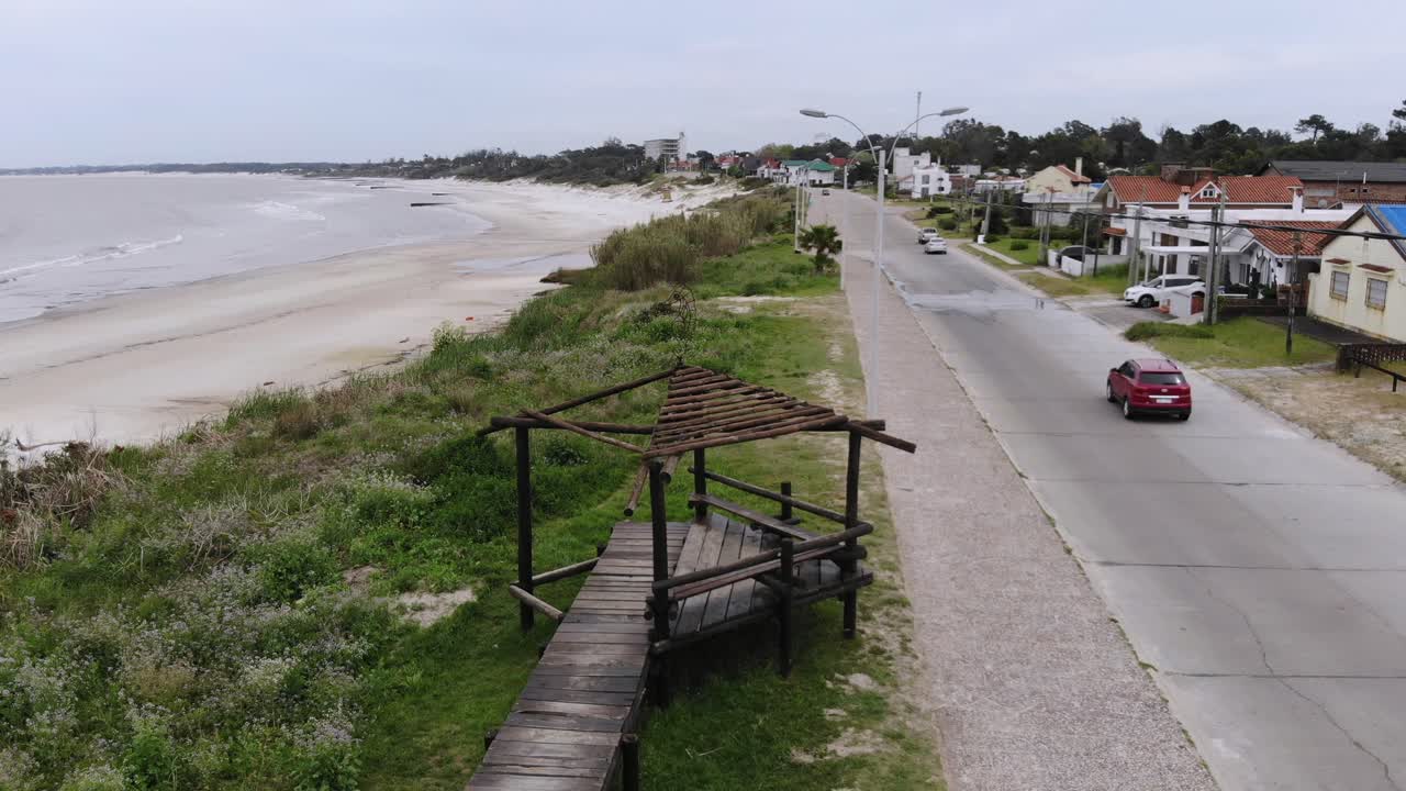 video aereo de una estructura de madera en la costa con la playa de fondo