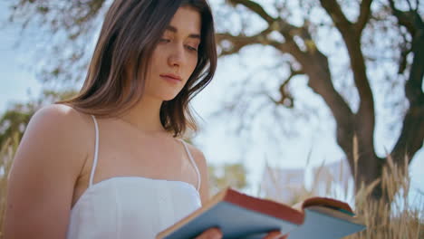 romantic girl holding book sitting nature closeup. tranquil woman enjoy reading