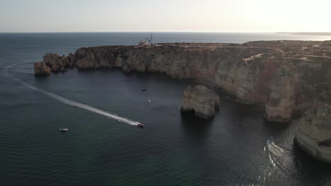 Aerial-Footage-From-Flying-Drone-Of-Tourist-Yachts-On-Clear-Blue-Water-In-Lagos,-Portugal