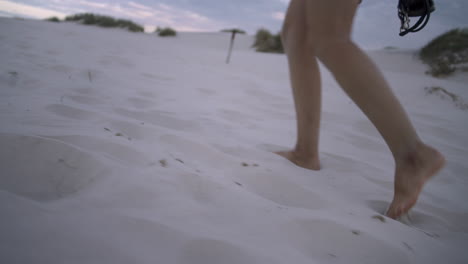 하얀 모래 언덕을 맨발로 걷는 여자