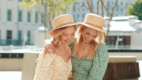 two happy women in floral dresses and straw hats