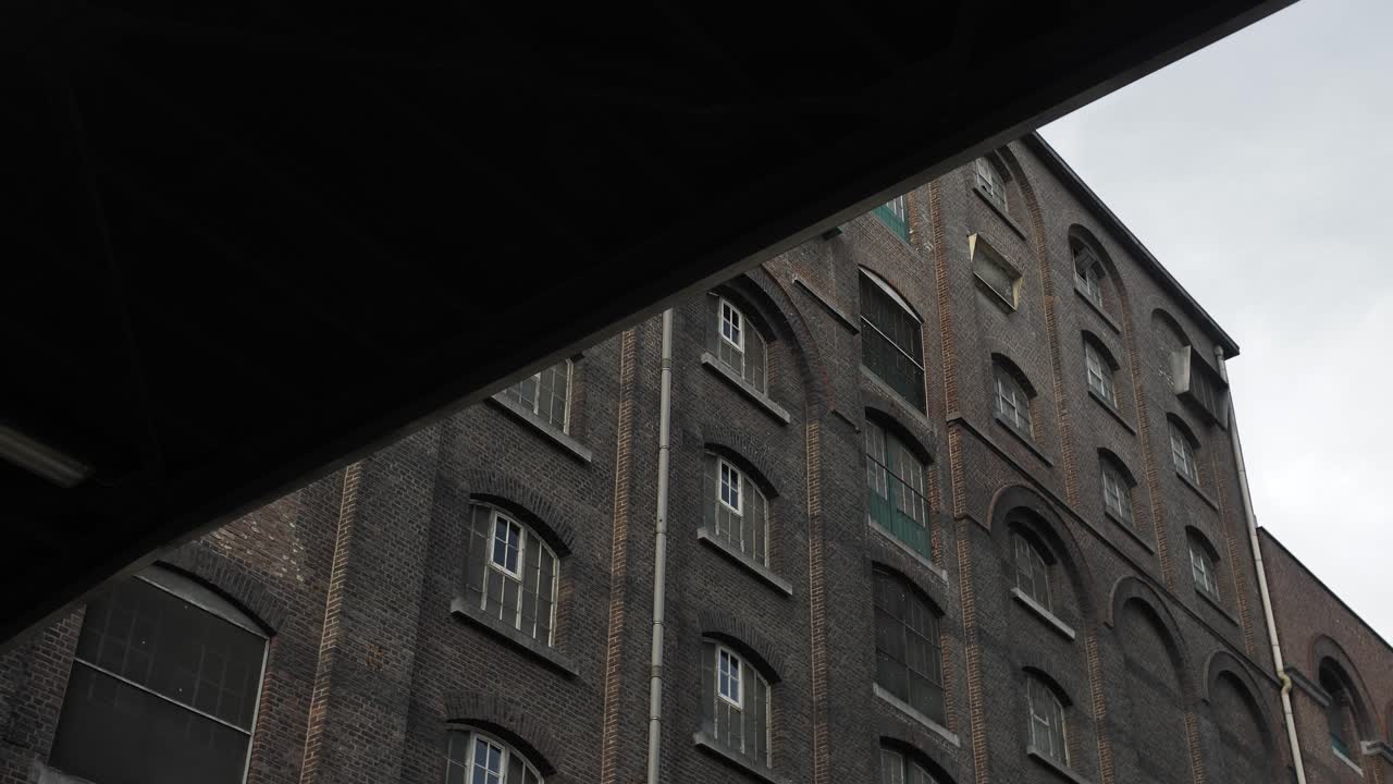 Slow motion shot uncovering the details of an aged factory building in an industrial area