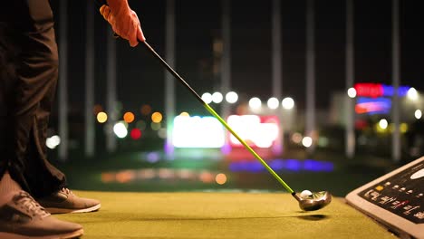 golfer practicing swing at night in bangkok