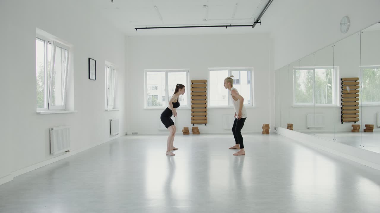 Due donne che ballano in uno studio bianco