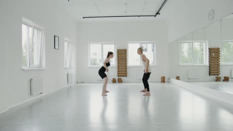 two women dancing in a white studio