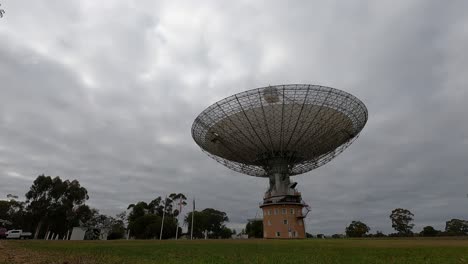 time-lapse of a satellite dish rotating under cloudy skies