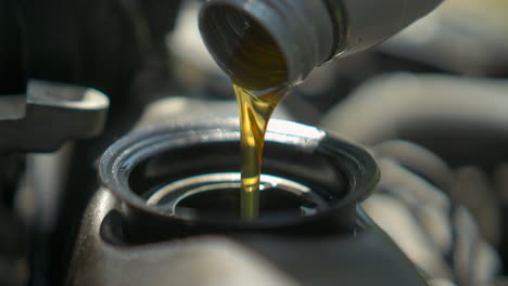 auto mechanic is changing motor oil