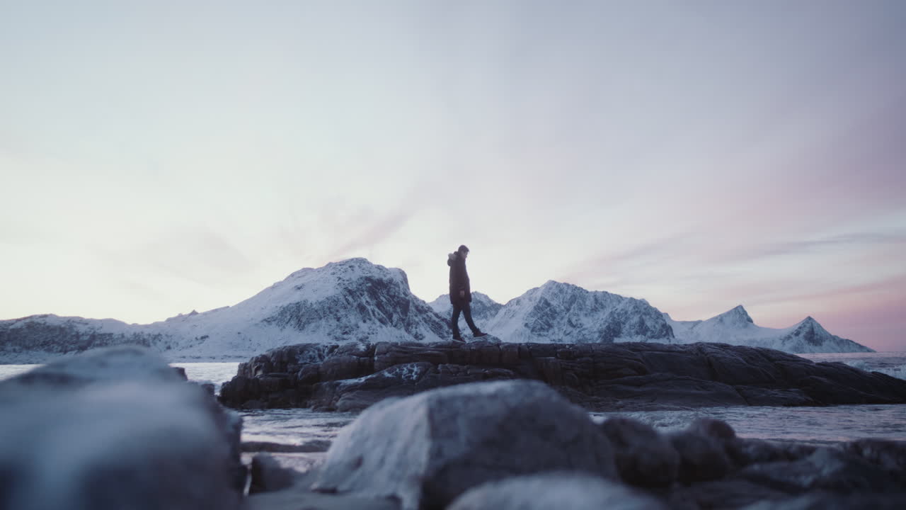 человек в отдаленном фьорде исследует скалы и море, лофотен, северные острова норвегии