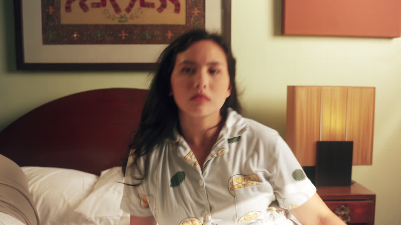 잠든 여자가 갑자기 일어나 집에 있는 침대에 앉았다