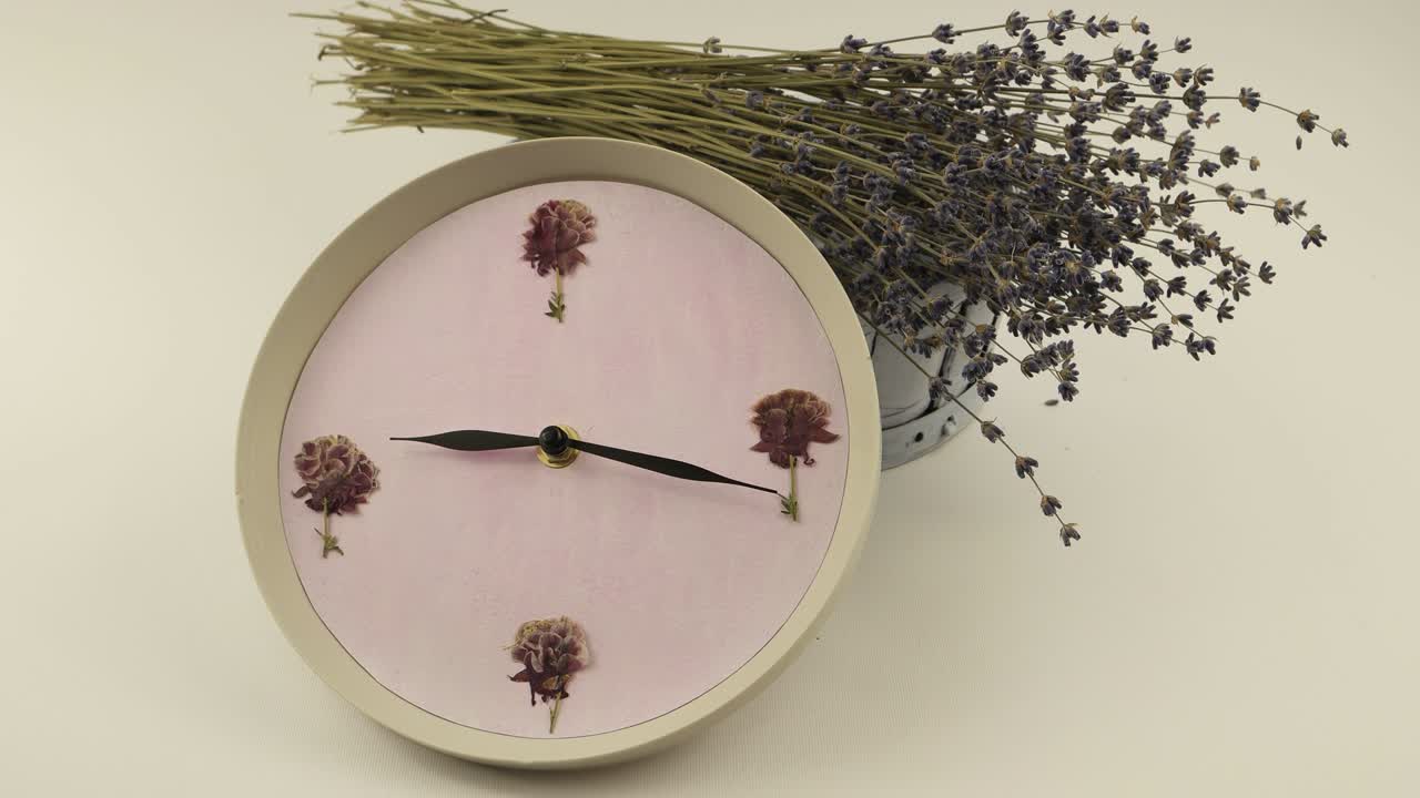 Klokke mot bakgrunnen av en blomsterkurv.