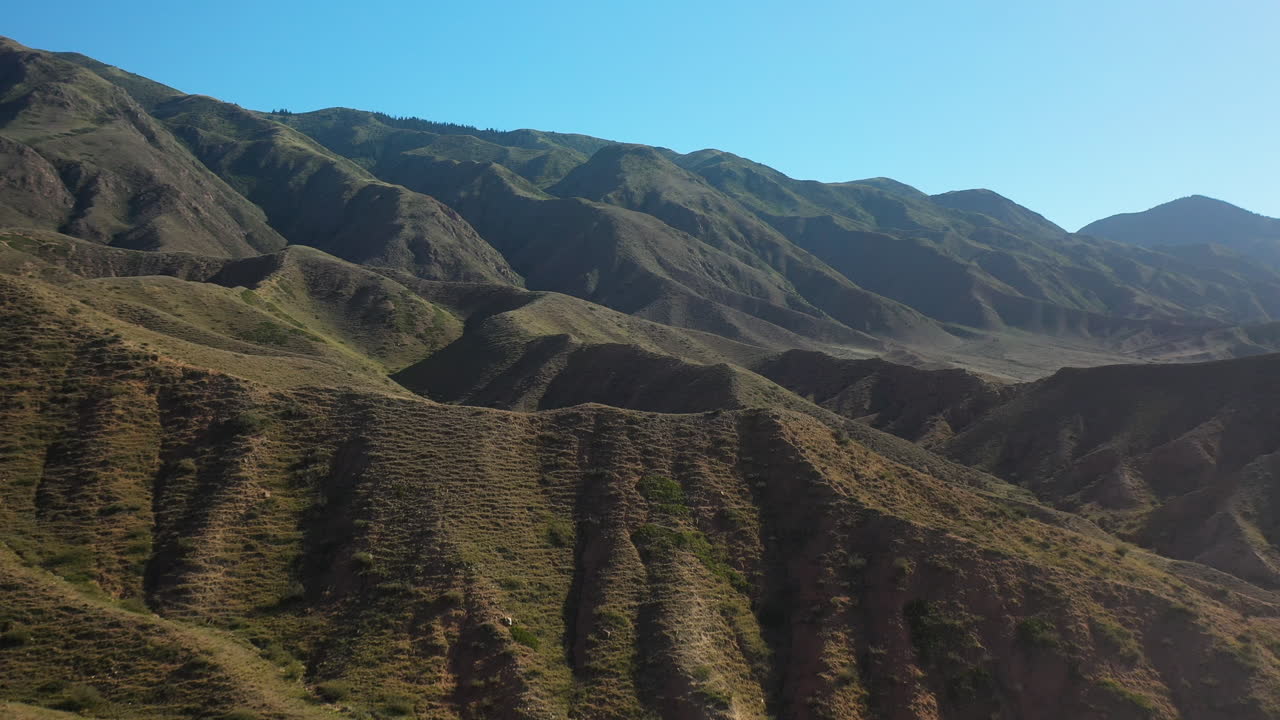 filmación de drones cinematográficos volando sobre las crestas de las montañas en el cañón de cuento de hadas cerca del lago issyk-kul en karakol, kirguistán