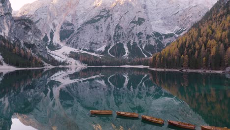 cinematic aerial view of italy's famous lake braies in italian dolomites on beautiful fall day