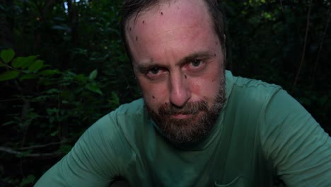 varios mosquitos aterrizan en la cara de un hombre mientras camina por los everglades de florida