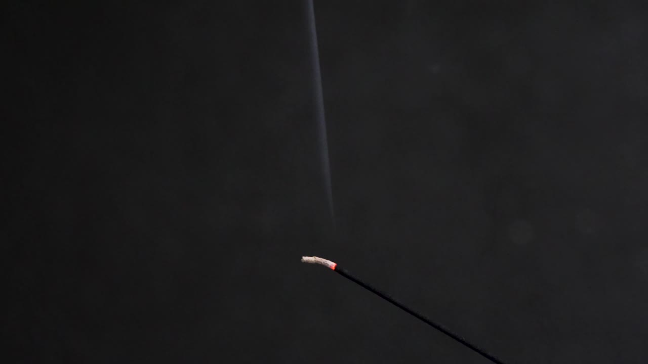 humo de incienso ardiendo contra un fondo oscuro