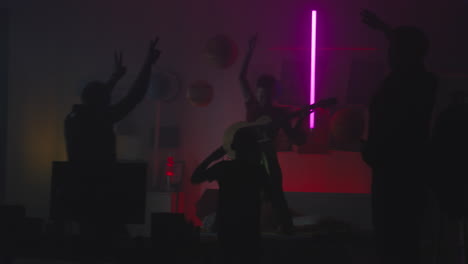 band performing in a neon-lit room