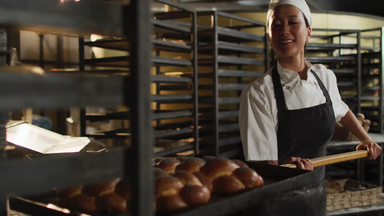 Animação de padeira asiática feliz segurando espátula de madeira com challah.
