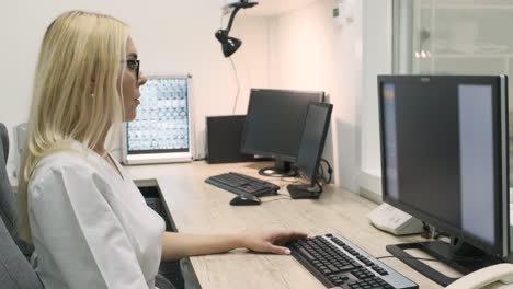una radióloga profesional examina los resultados de una tomografía computarizada o una resonancia magnética, trabajando en una pantalla de computadora en su escritorio personal en el hospital