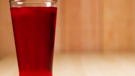 a glass filled with red soft drink