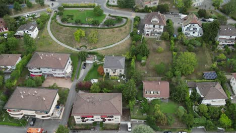 aerial view, tilt up with drone: residential area in lausanne town: houses, buildings and gardens