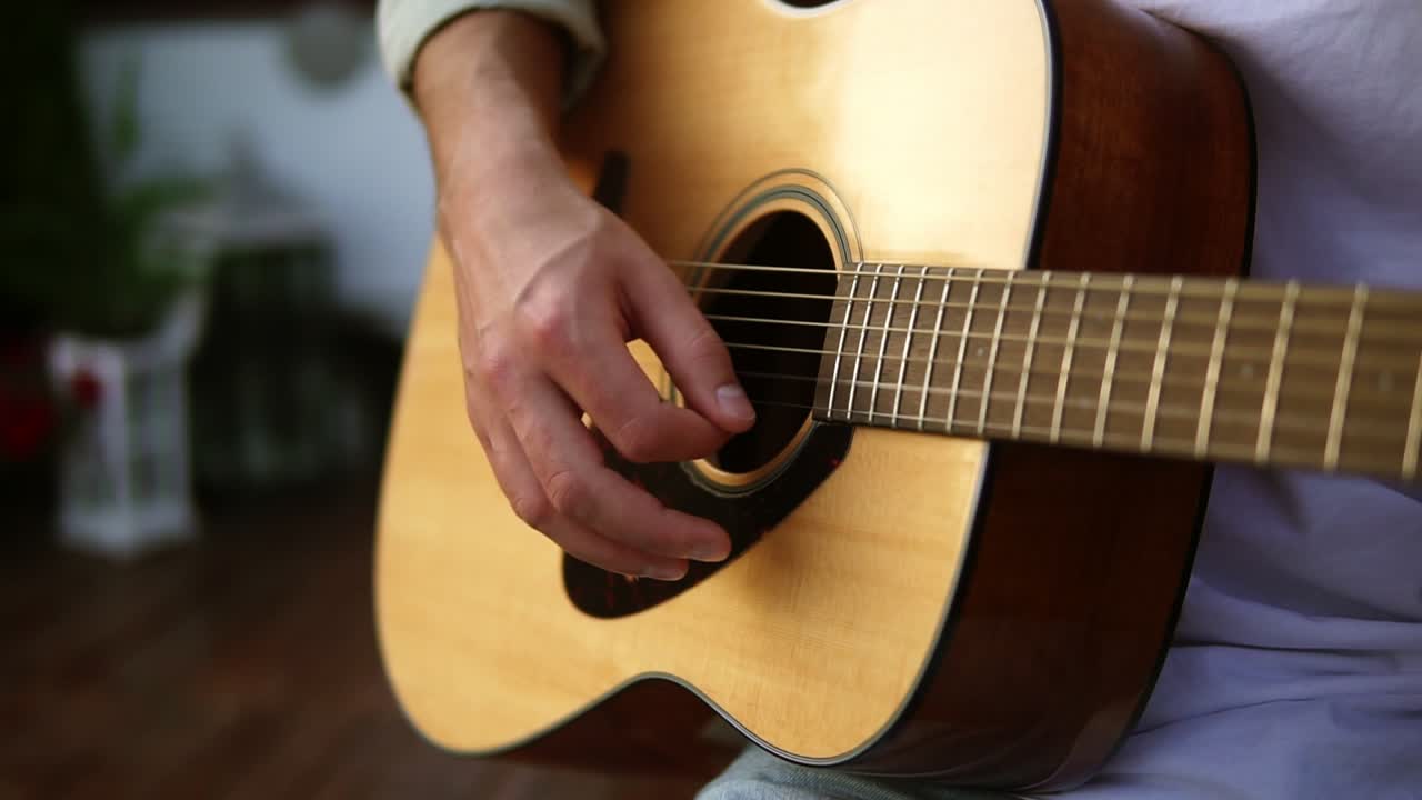 Close up of man's hands playing acoustic guitar. Musical instrument for recreation or hobby passion concept. Outdoors