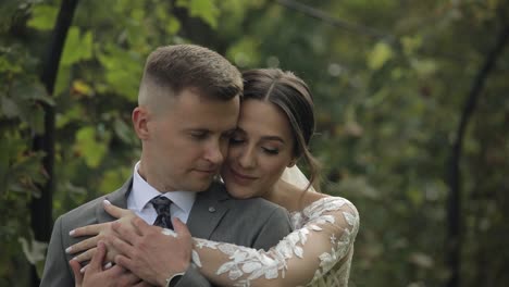 lovely newlyweds caucasian bride embracing groom in park making kiss, wedding couple family hugging