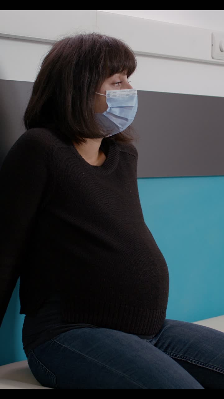 Pregnant Woman Wearing Medical Mask in Doctor's Office