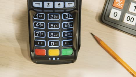 payment terminal. a man enters a pin code. close up of a hand on a credit card pin pad at a retail store.