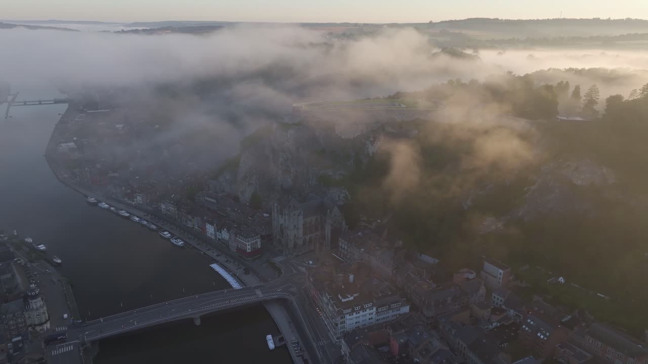 Veduta aerea di Dinant con la città, la cittadella e una barca, che mostra uno scenario storico suggestivo in Belgio con dettagli mozzafiato.