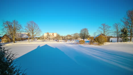 a beautiful sunset shot of a winter landscape with rural houses and snowy meadows