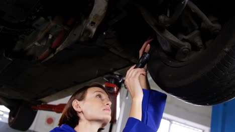 mecánica examinando el disco de freno de la rueda del coche