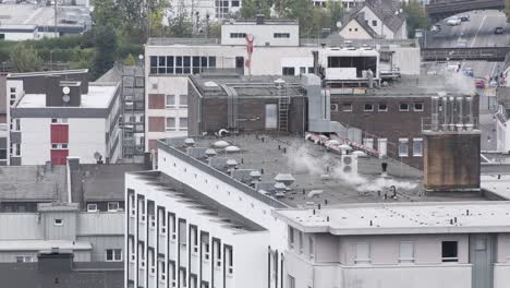 Urban-gray-concrete-city-rooftops-of-city-buildings-and-road-with-driving-cars-in-background