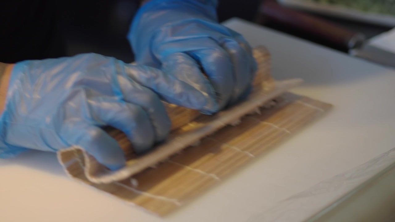 Chef Preparing Sushi Roll with Bamboo Mat