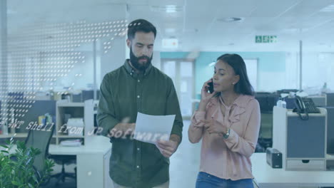 Walking through office, business colleagues discussing documents and talking on phone