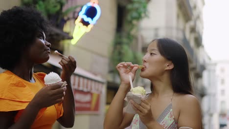 Two friends eating ice cream on the street