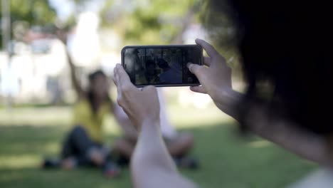 Woman-photographing-friends-with-cell-phone