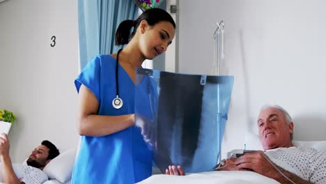 Female-doctor-discussing-x-ray-report-with-male-senior-patient-in-the-ward