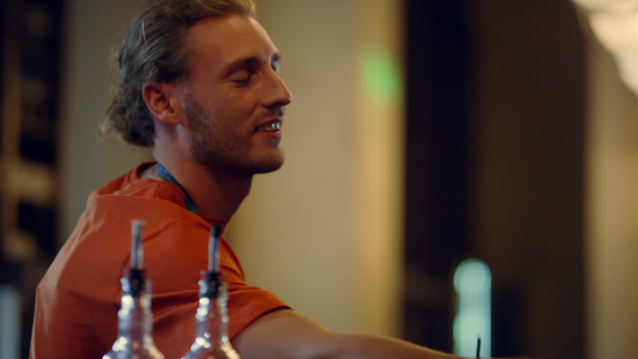 un bel barista che accetta il pagamento in casa. un barista che sorride in casa.