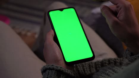 man tapping on mobile phone green screen at home