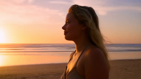 blonde woman enjoying a serene sunset on the beach