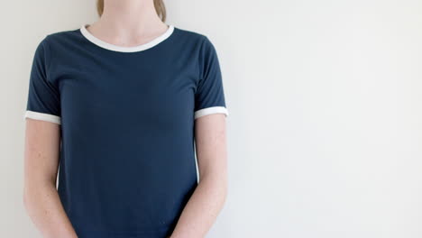 sección media de una mujer caucásica en camiseta azul marino con bordes blancos, espacio de copia, cámara lenta