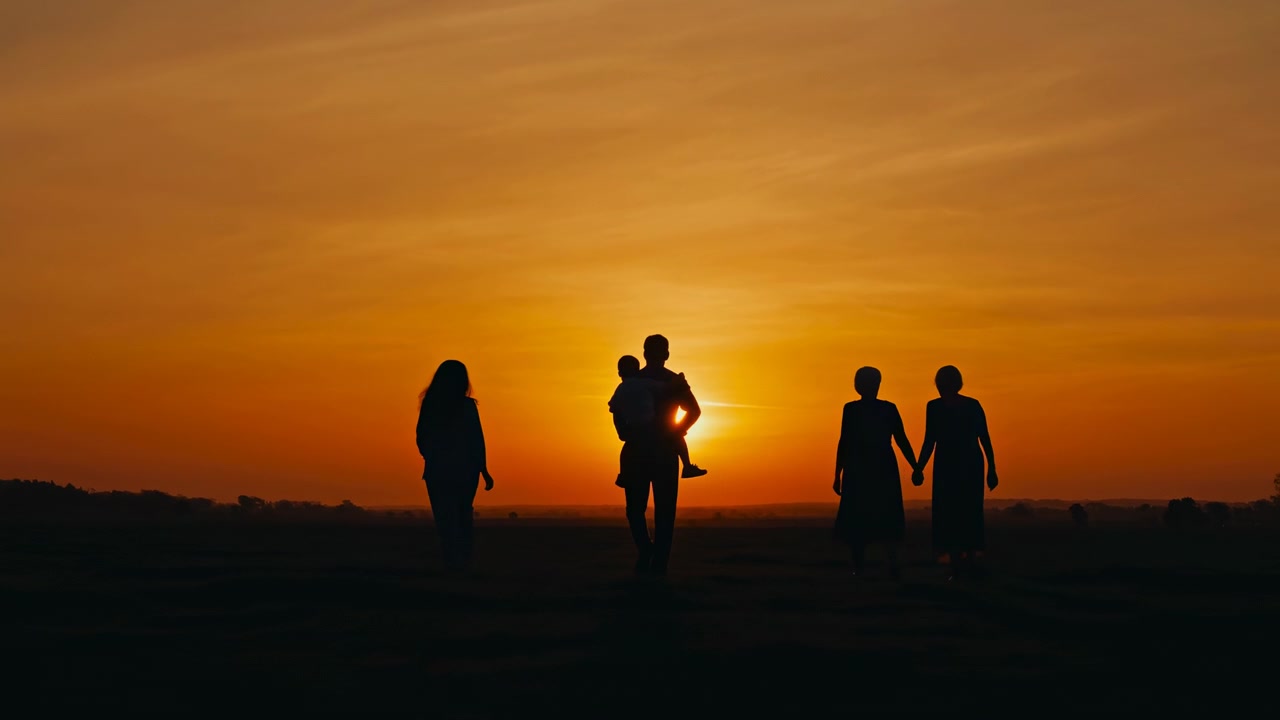 Five silhouetted figures stand on open plain at sunset, with central adult carrying child before low sun, creating bright halo around heads and shoulders, warm sky, strong contrast, and calm open
