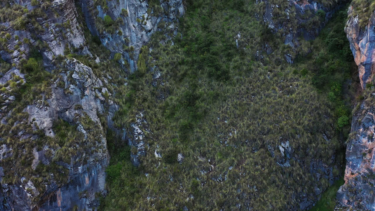 Beautiful drone shot of a mountain with rock and vegetation around Millpu Lake in Ayacucho, Peru on a cloudy day